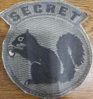 military green fabric patch with the word secret and a picture of a squirrel