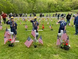 Picture of Boy Scouts standing near graves decorated by flags